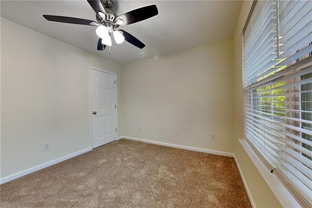 1595 Stephens Pond View Loganville, GA 30052 - Photo 16 of 22 en empty room with windows and ceiling fan