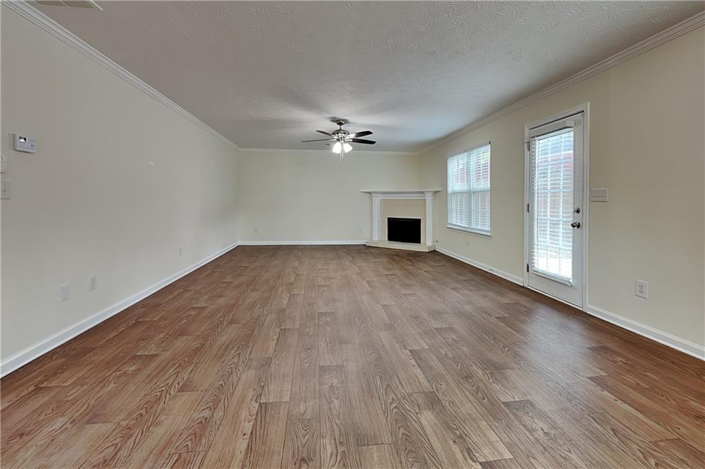 1595 Stephens Pond View Loganville, GA 30052 - Photo 2 of 22 wooden floor in an empty room with a ceiling fan