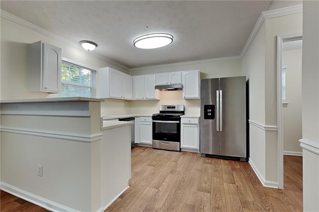 1595 Stephens Pond View Loganville, GA 30052 - Photo 5 of 22 a kitchen with a refrigerator and a stove top oven