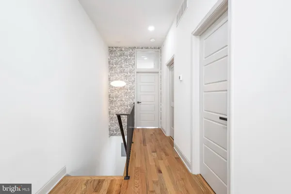a view of a hallway with wooden floor and staircase