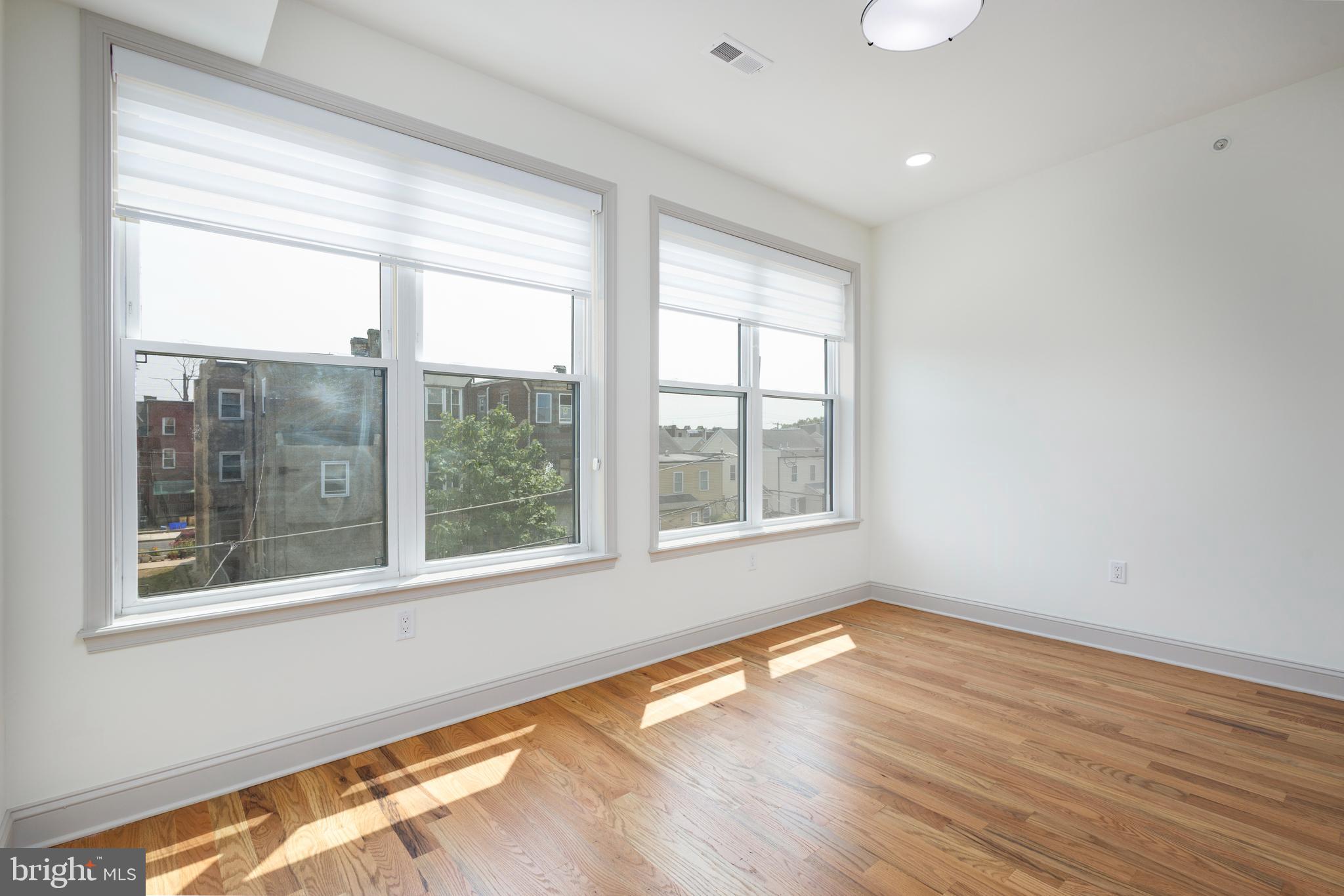 3116 Clifford Street, Unit B Philadelphia, PA 19121 - Photo 26 of 32 a view of an empty room with wooden floor and a window