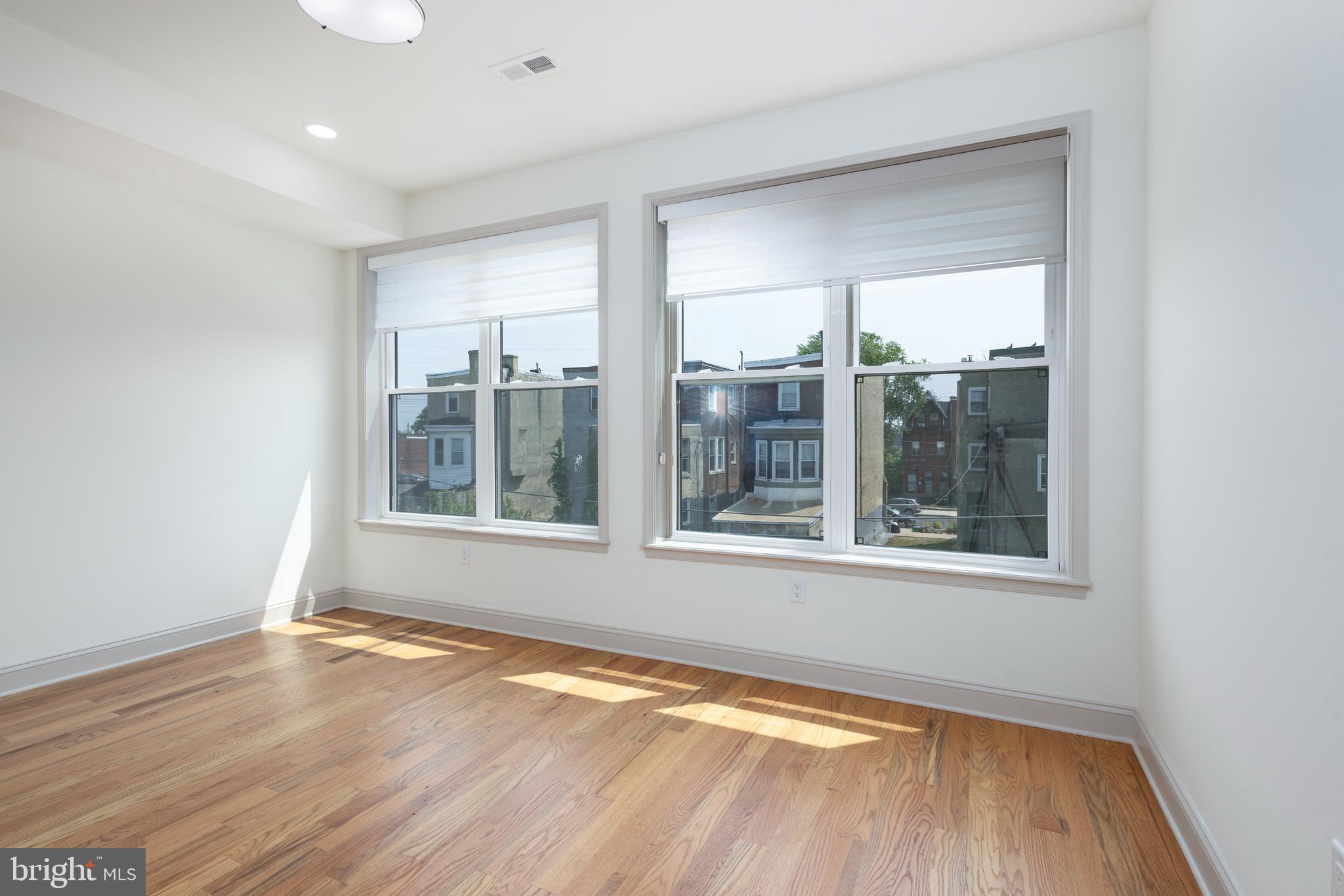 3116 Clifford Street, Unit B Philadelphia, PA 19121 - Photo 27 of 32 an empty room with wooden floor and windows