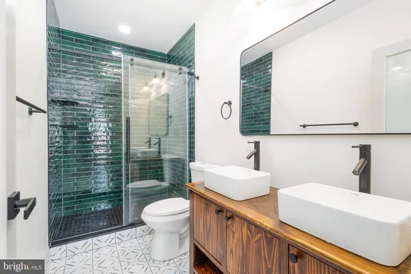 a bathroom with a double vanity sink toilet and shower