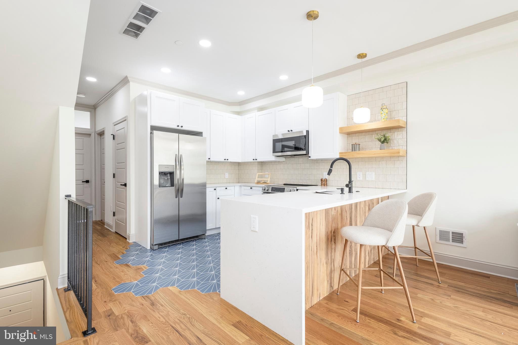 3116 Clifford Street, Unit B Philadelphia, PA 19121 - Photo 4 of 32 a kitchen with stainless steel appliances granite countertop a refrigerator and a stove top oven