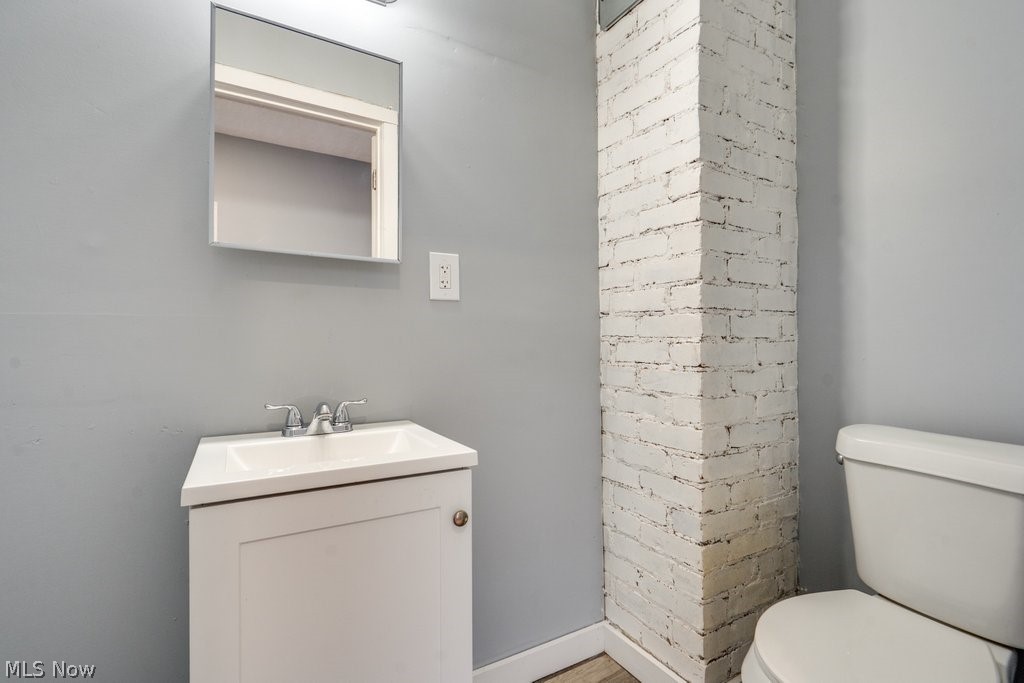 1607 9th Street Southwest Canton, OH 44706 - Photo 14 of 41 Bathroom featuring a white vanity with sink, mirror, chrome faucet, and exposed brick column