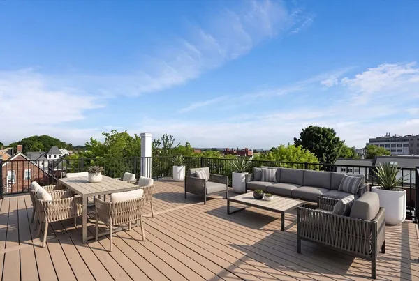 a view of roof deck with couches and sky view