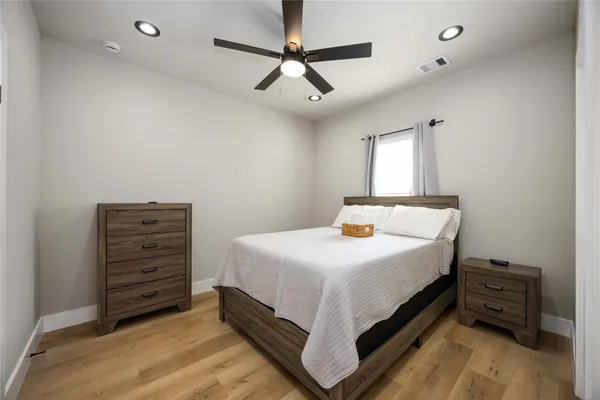 a bedroom with a bed and a refrigerator