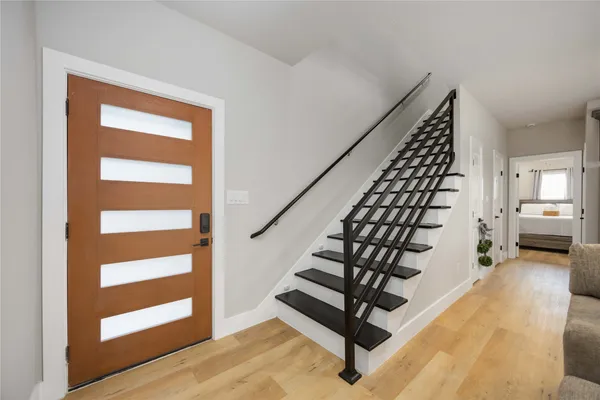 a kitchen with stainless steel appliances granite countertop a sink a stove a refrigerator cabinets and chairs