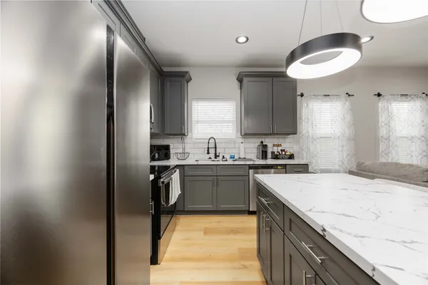 a kitchen with kitchen island granite countertop a sink stainless steel appliances and cabinets