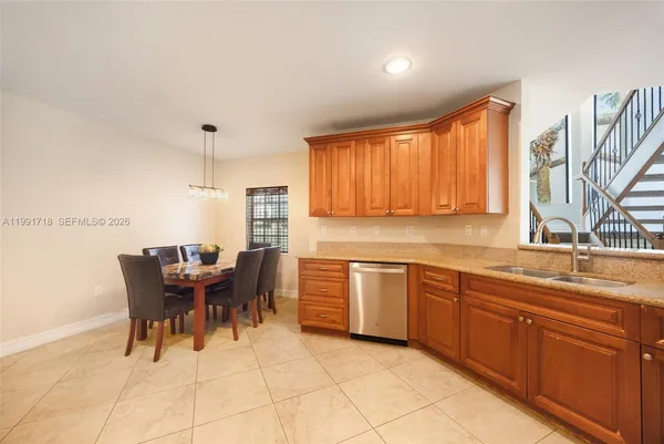a kitchen with stainless steel appliances granite countertop a sink and a refrigerator