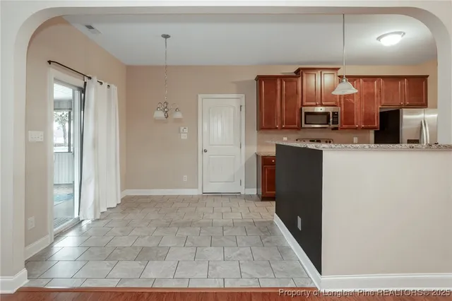 a kitchen with stainless steel appliances a refrigerator and a stove top oven