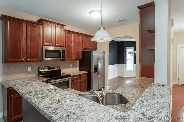 a kitchen with stainless steel appliances granite countertop a sink refrigerator and microwave