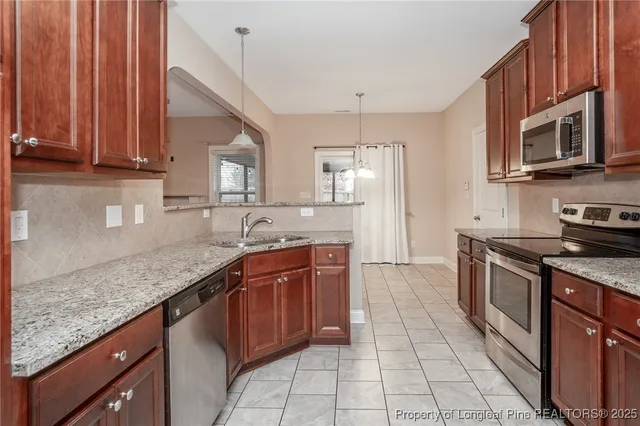 a kitchen with stainless steel appliances granite countertop a sink stove and cabinets