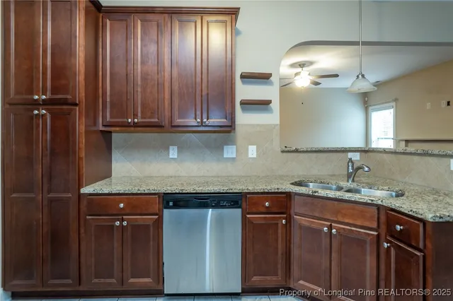 a kitchen with granite countertop wooden cabinets and a sink