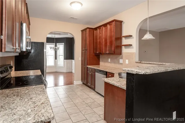 a large kitchen with granite countertop a sink and a stove
