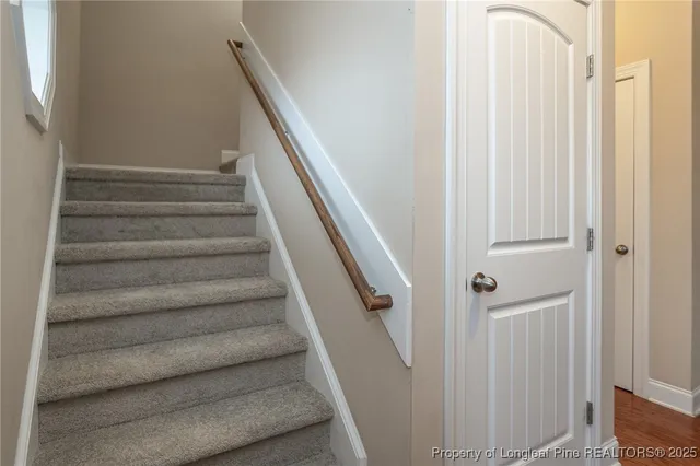 a view of staircase with white walls and railing