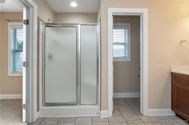 a view of an empty room with closet and a mirror