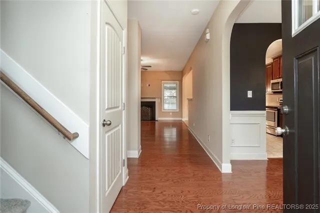 a view of hallway with stairs and wooden floor