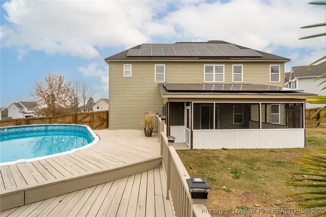a view of backyard with swimming pool and seating space