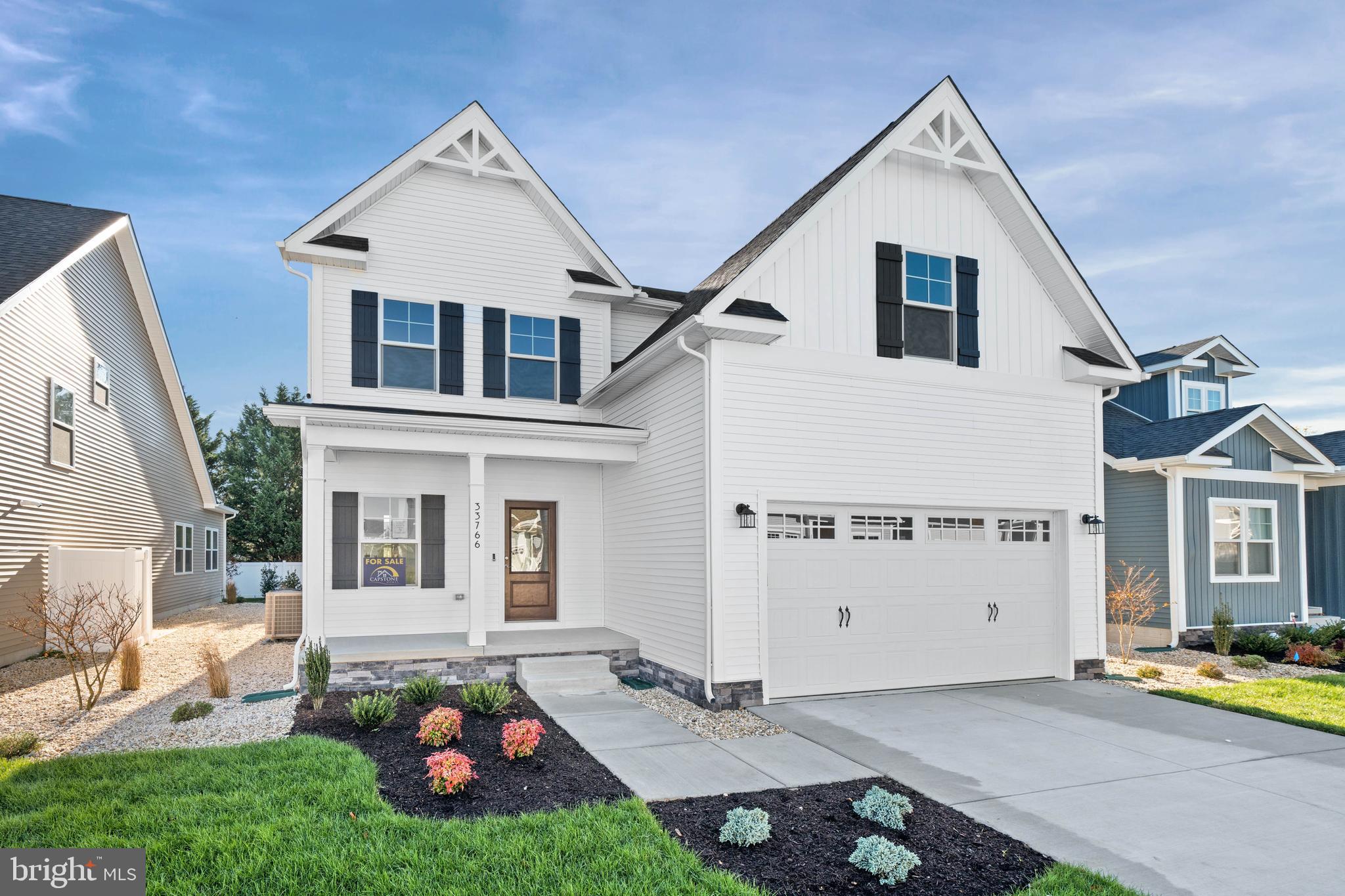 33766 Catching Cove Lewes, DE 19958 - Photo 2 of 47 a view of a white house next to a big yard with large trees