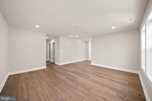 a view of an empty room with wooden floor