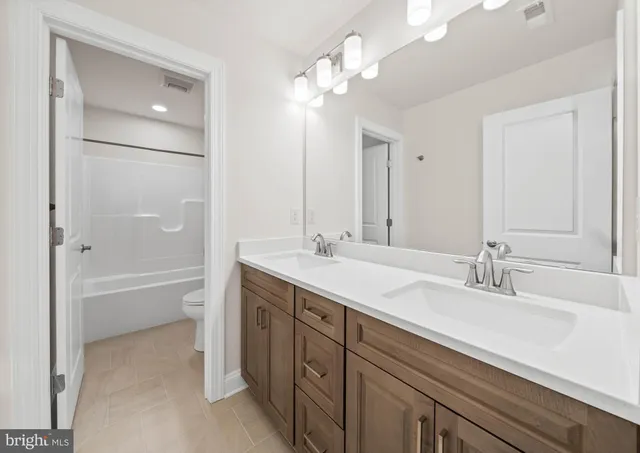 a bathroom with a tub a sink and mirror