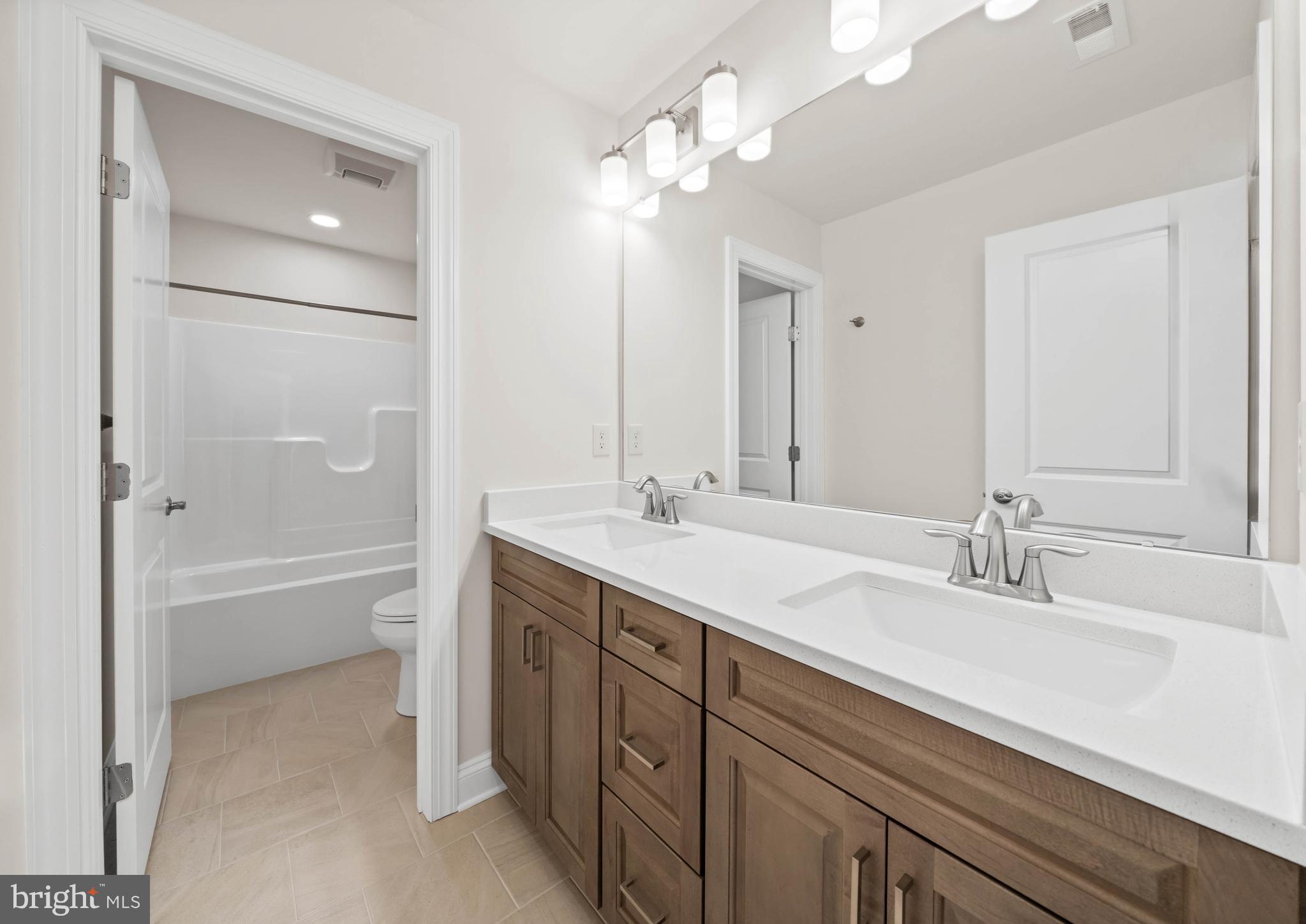 33766 Catching Cove Lewes, DE 19958 - Photo 29 of 47 a bathroom with a tub a sink and mirror