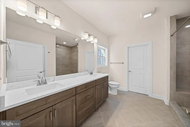 a spacious bathroom with a double vanity sink toilet mirror and double