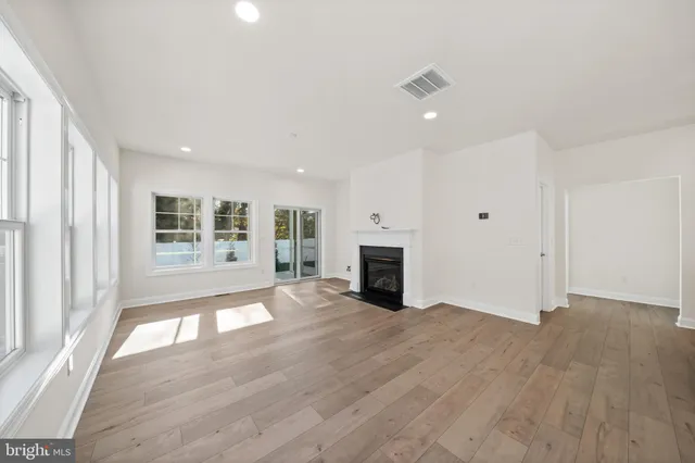 an empty room with wooden floor and fireplace