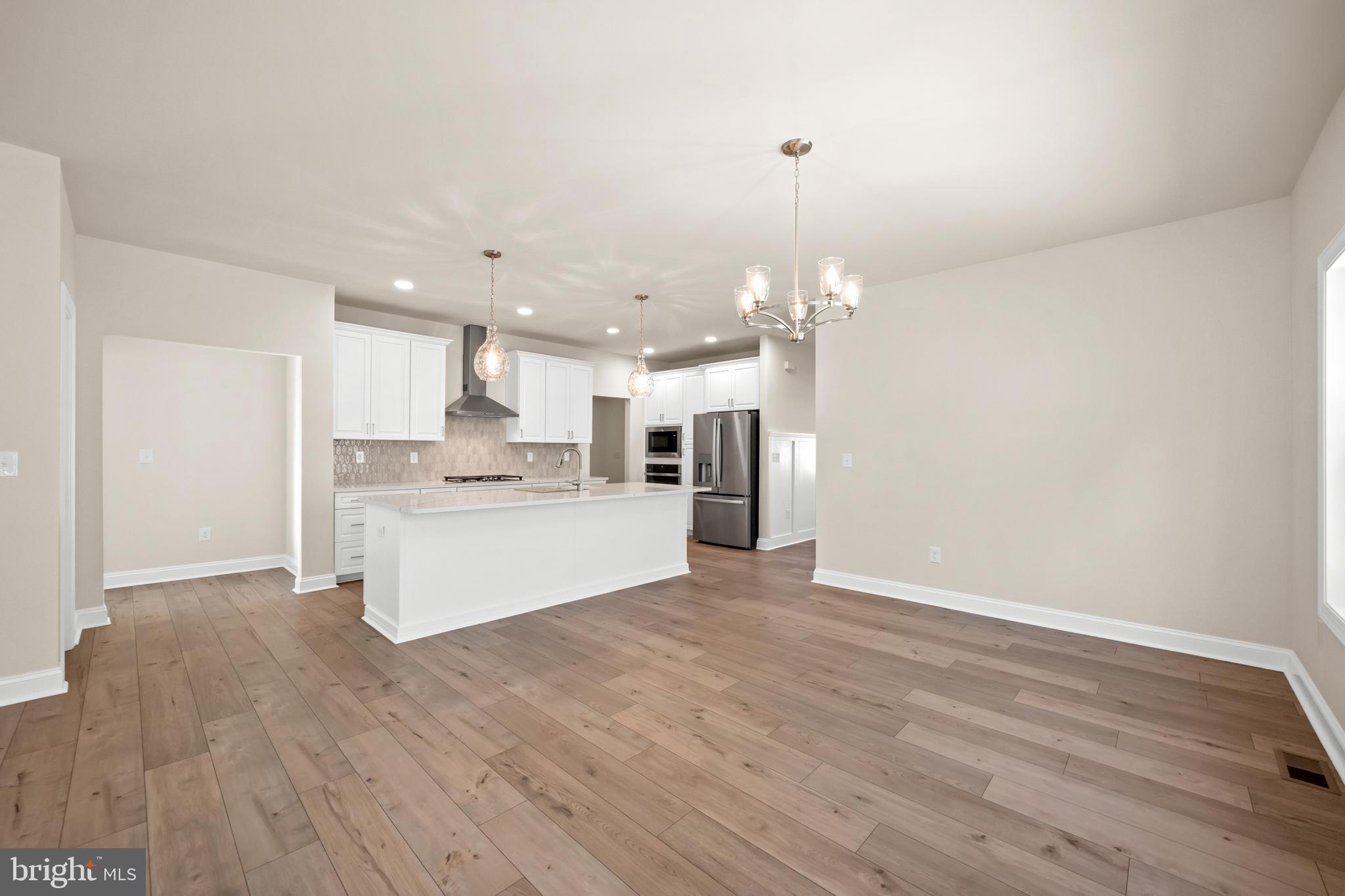 33766 Catching Cove Lewes, DE 19958 - Photo 8 of 47 a view of kitchen with kitchen island a sink wooden floor and a refrigerator