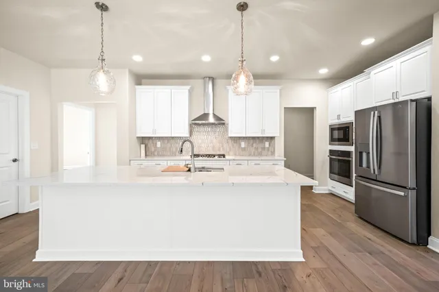 a view of a kitchen with stainless steel appliances a refrigerator a sink and a stove