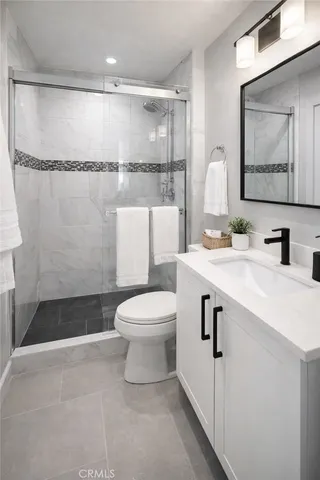 a bedroom with a large bed and a flat tv screen on dresser