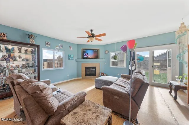 a living room with furniture a fireplace and a floor to ceiling window