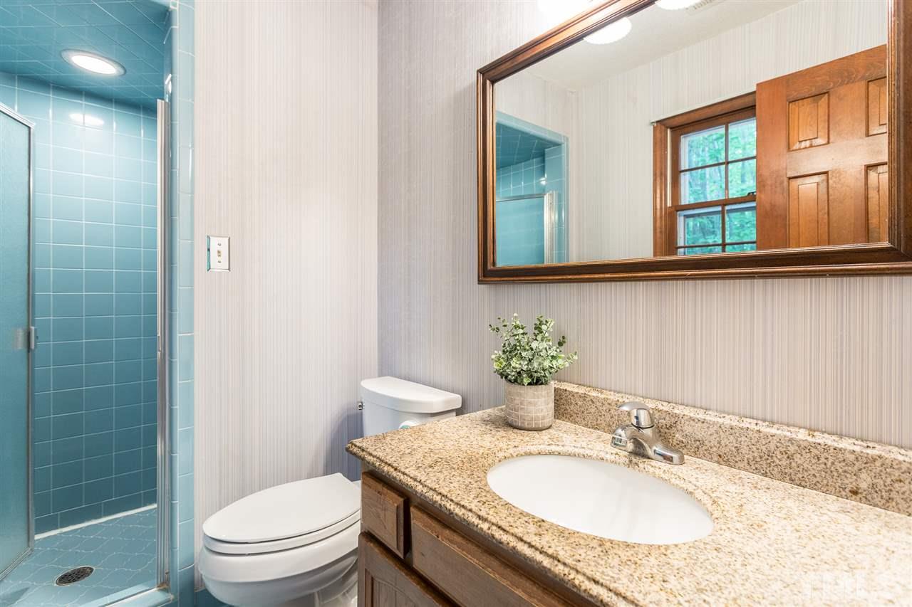 10005 Bavin Place Raleigh, NC 27613 - Photo 15 of 30 a bathroom with a granite countertop toilet a sink and a mirror