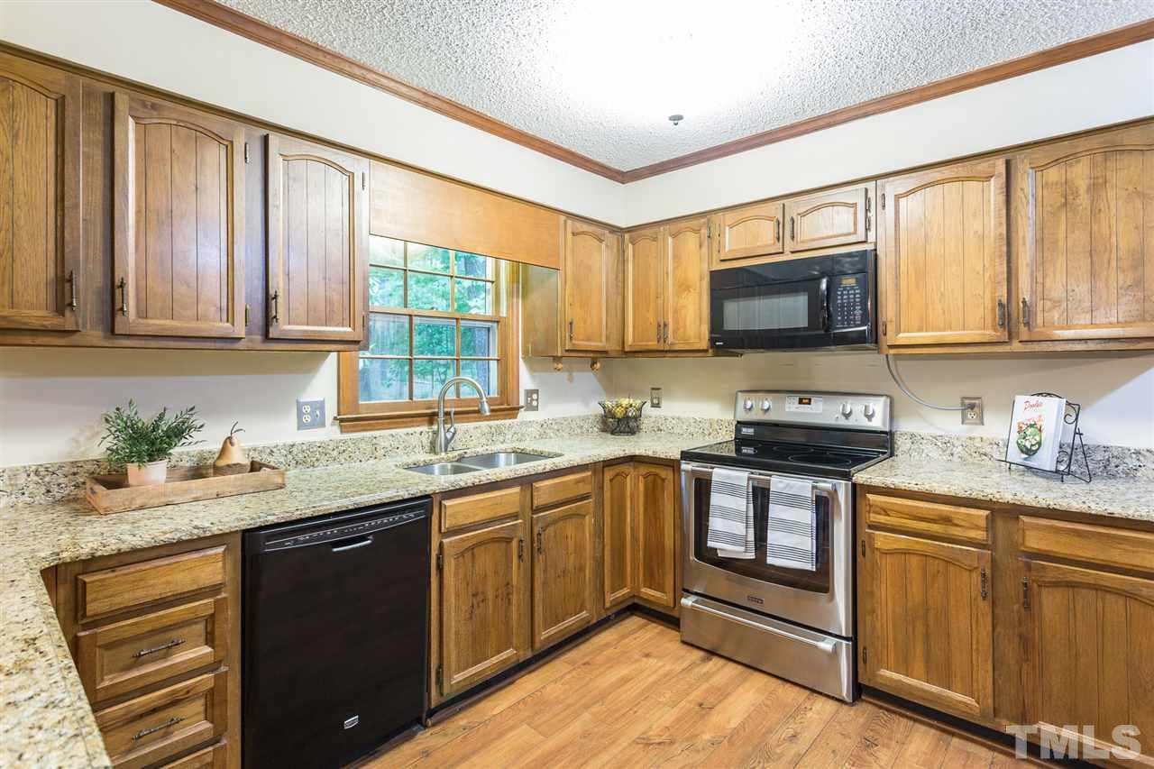 10005 Bavin Place Raleigh, NC 27613 - Photo 8 of 30 a kitchen with stainless steel appliances granite countertop a sink stove and microwave