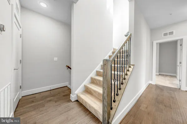 a view of a hallway with wooden floor and staircase