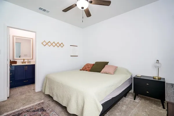 a bedroom with a bed and a chandelier fan