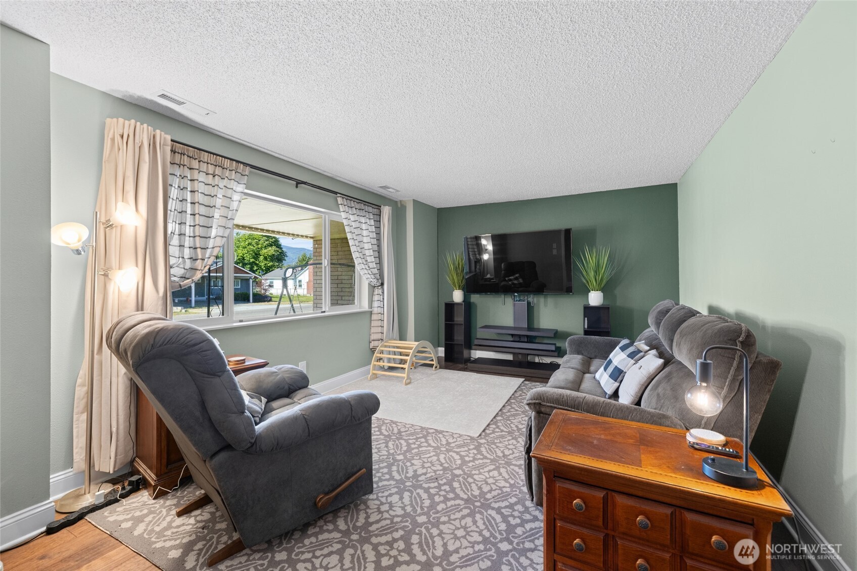 415 Sterling Street Sedro-Woolley, WA 98284 - Photo 8 of 38 a living room with furniture a flat screen tv and a large window