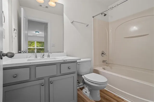 a bathroom with a granite countertop sink toilet and a mirror