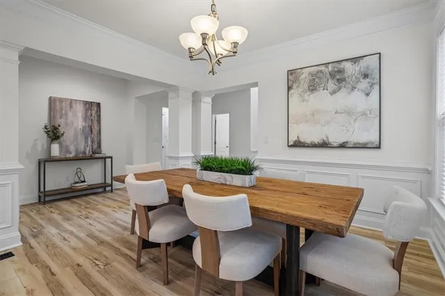 a view of a dining room with furniture a chandelier and wooden floor