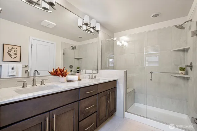 a bathroom with a double vanity sink mirror and shower
