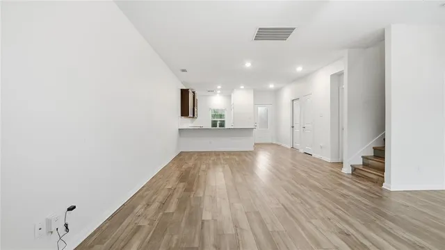 a view of a big room with wooden floor and windows