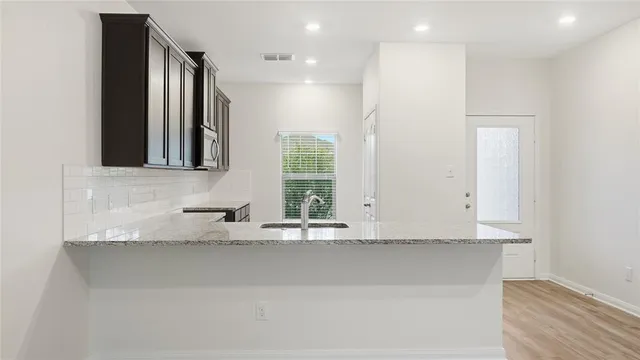 a kitchen with granite countertop white cabinets and window