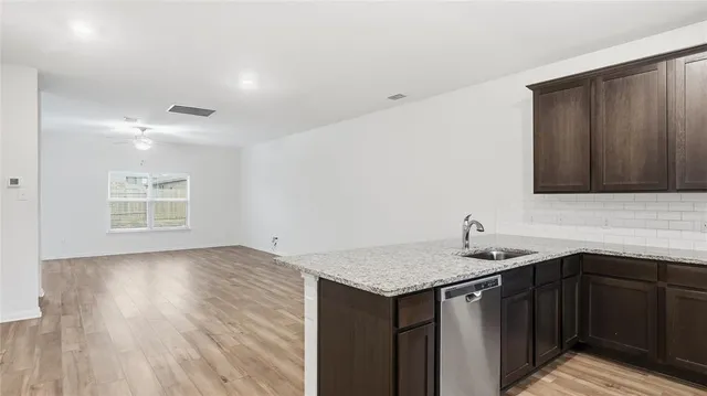 a kitchen with a sink cabinets and wooden floor