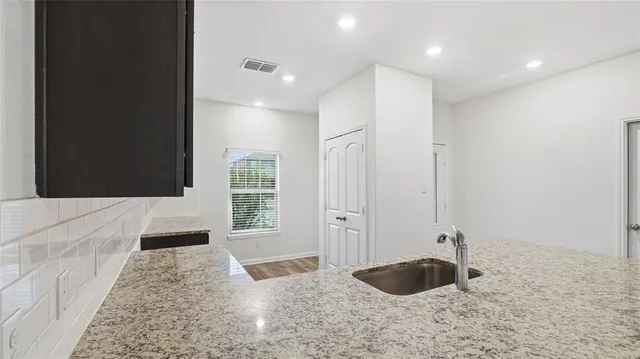 a bathroom with a granite countertop sink a toilet and bathtub