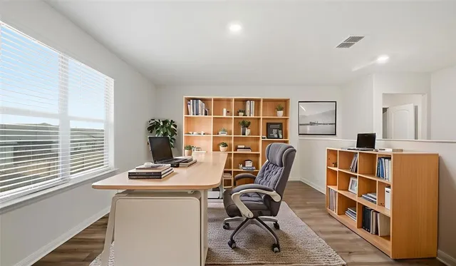 a workspace with furniture a bookshelf and a window