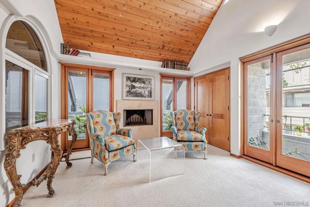 a living room with furniture a fireplace and large windows