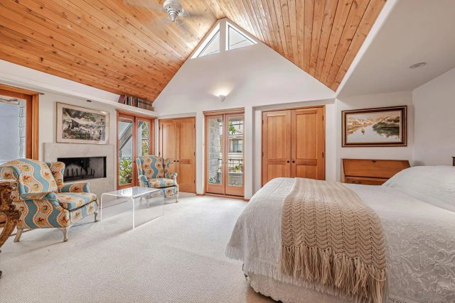 a spacious bedroom with a bed a couch and large window