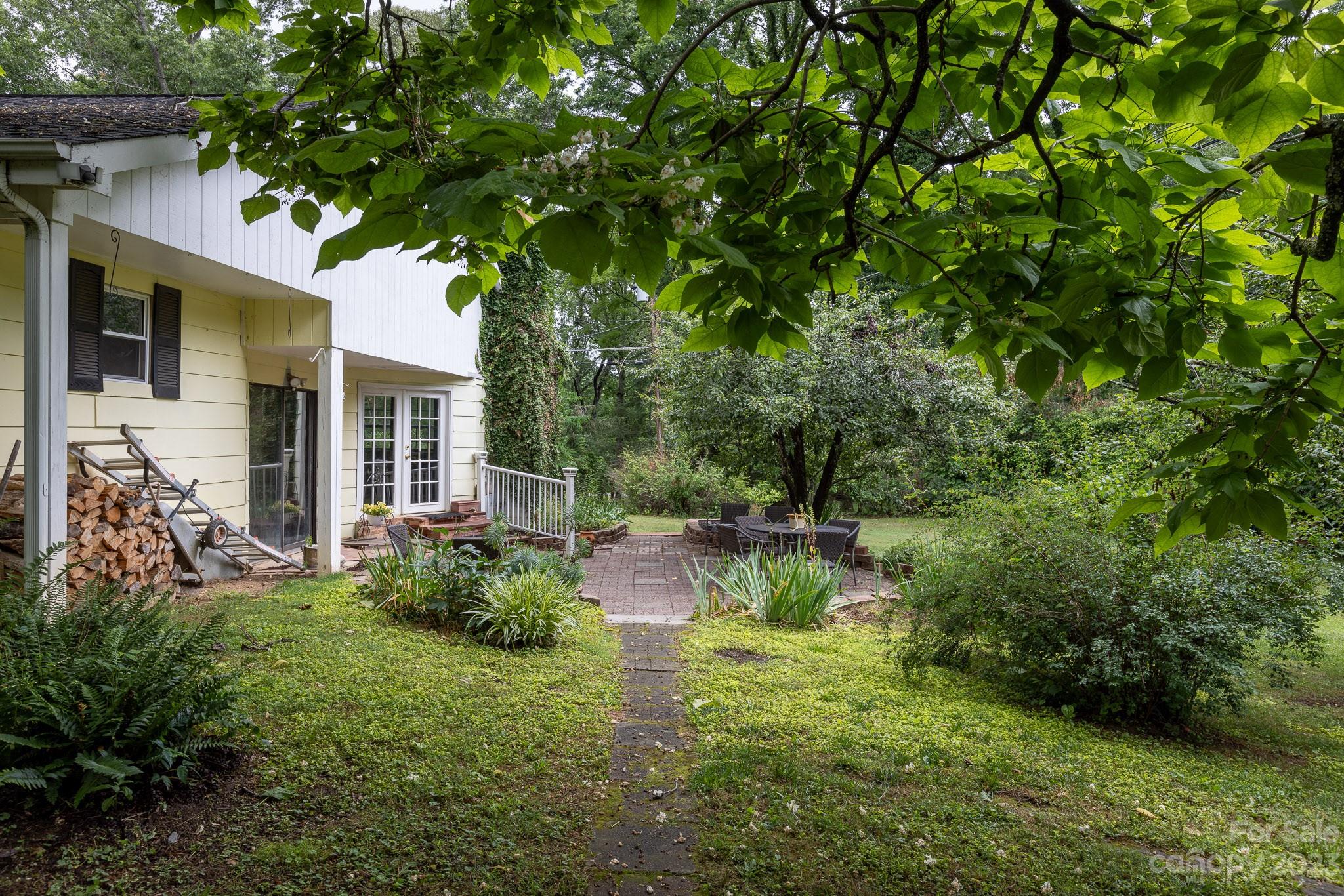 777 Glenn Bridge Road Arden, NC 28704 - Photo 22 of 22 a backyard of a house with plants and large tree