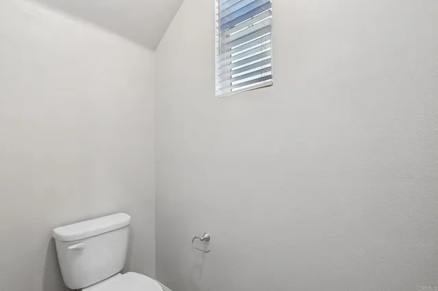 a white toilet sitting next to a window